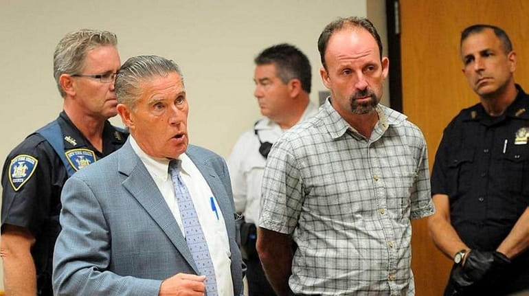 Manorville carpenter John Bittrolff, center, stands with his lawyer William...