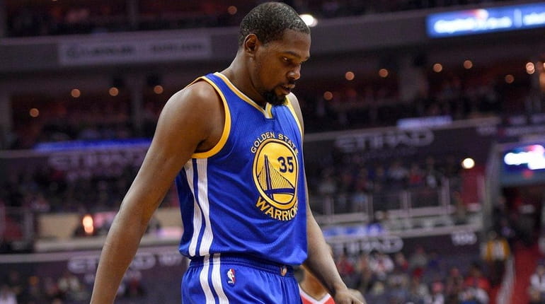 Golden State Warriors forward Kevin Durant walks to the bench...