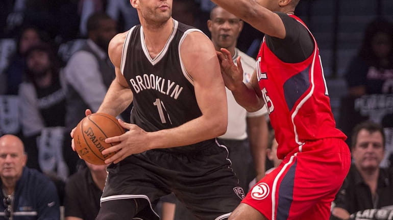Brooklyn Nets' Brook Lopez looks to pass the ball while...
