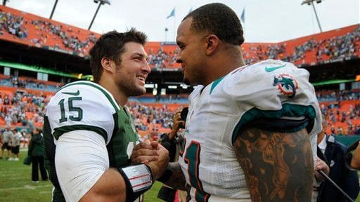 Tim Tebow and Miami Dolphins center Mike Pouncey greet each...