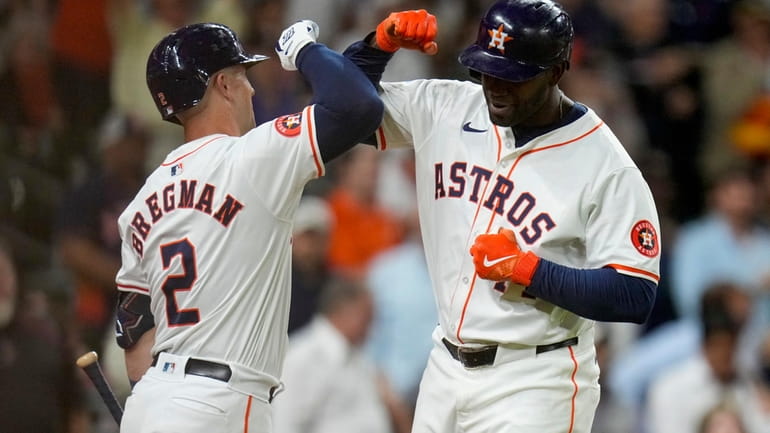 Houston Astros designated hitter Yordan Alvarez, right, celebrates with Alex...