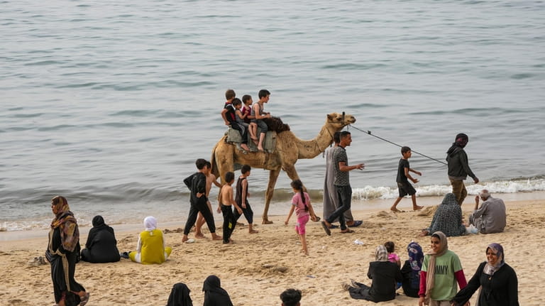 Palestinians spend the day on the beach along the Mediterranean...