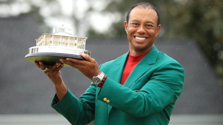 Tiger Woods celebrates with the Masters Trophy during the Green Jacket...