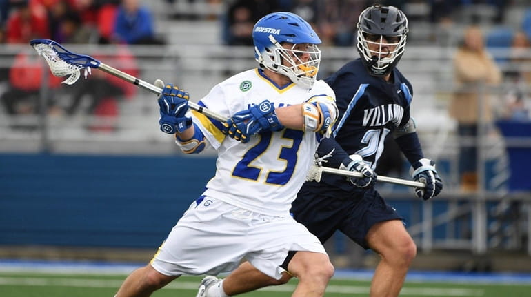Hofstra midfielder Dylan Alderman winds up to shoot defended by...