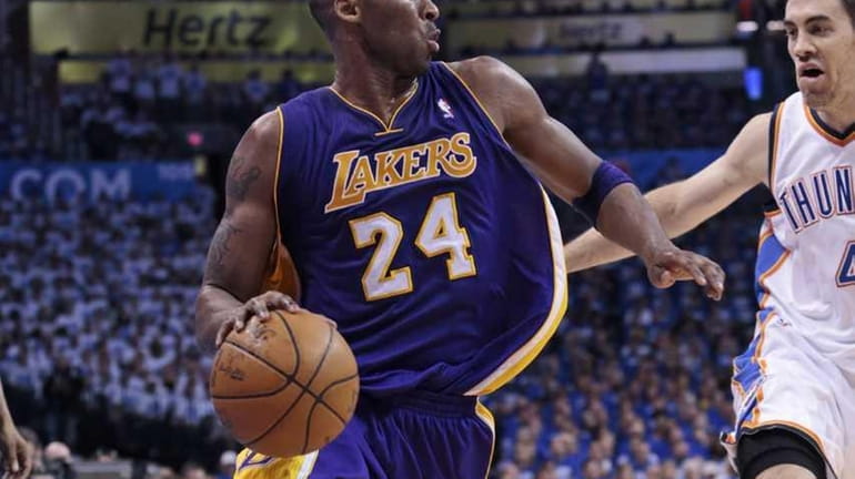 Kobe Bryant #24 of the Los Angeles Lakers drives around...