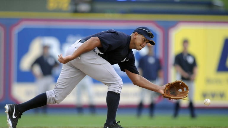 Yankees third baseman Alex Rodriguez reaches for a ground ball...