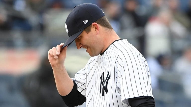 Yankees relief pitcher Adam Warren adjusts his cap before throwing...