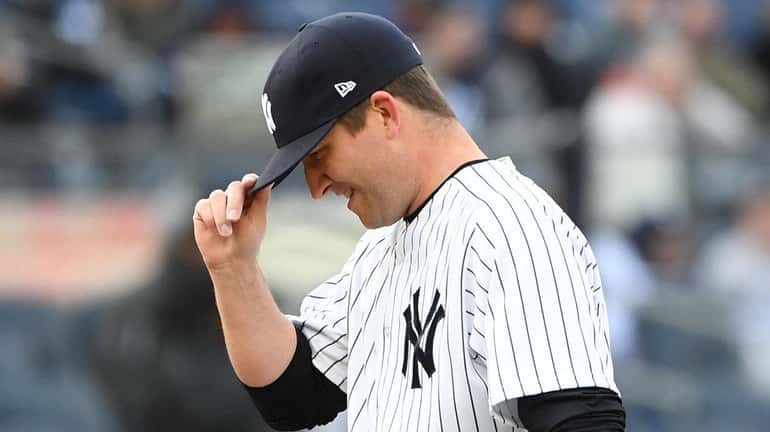 Yankees relief pitcher Adam Warren adjusts his cap before throwing...
