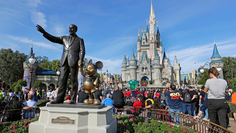 A statue of Walt Disney and Micky Mouse stands in...