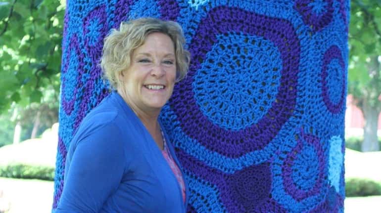"Yarn-bombing" pioneer and artist Carol Hummel stands by a tree...
