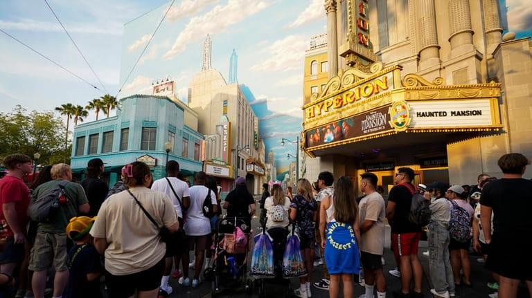 Park guests stand outside the world premiere of Disney's "Haunted...