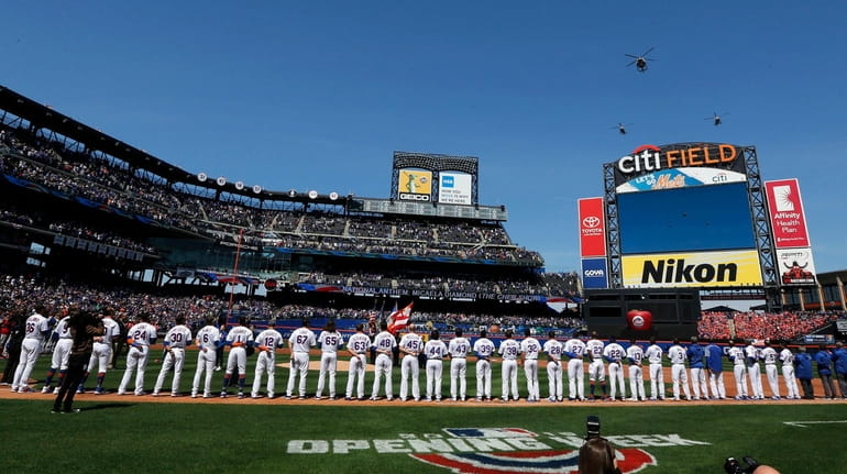 The Mets stand for the national anthem ahead of their...