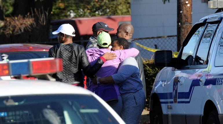 Relatives comfort one another outside a West Babylon home, where...