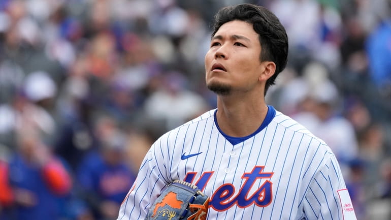 New York Mets pitcher Kodai Senga walks off the field...