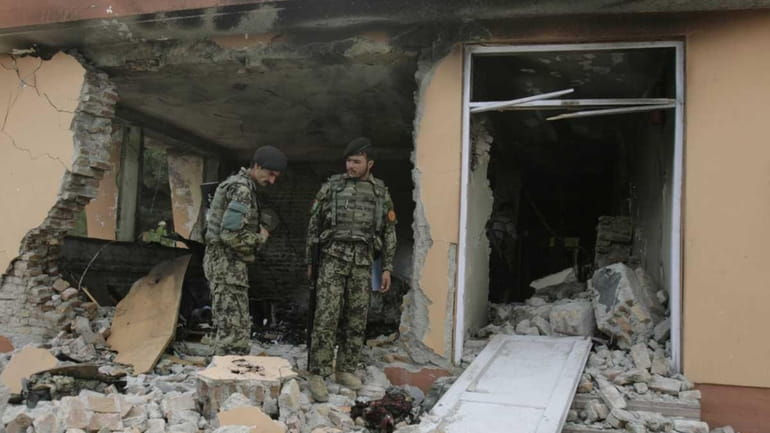 Afghan soldiers inspect the damaged building inside governor's compound in...