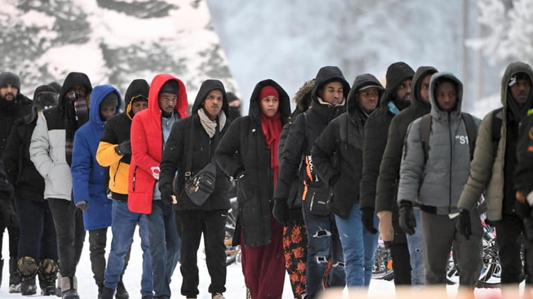 Migrants arrive at the international border crossing between Finland and...