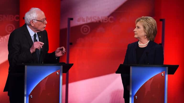 Democratic presidential candidate Hillary Clinton listens as Bernie Sanders speaks...
