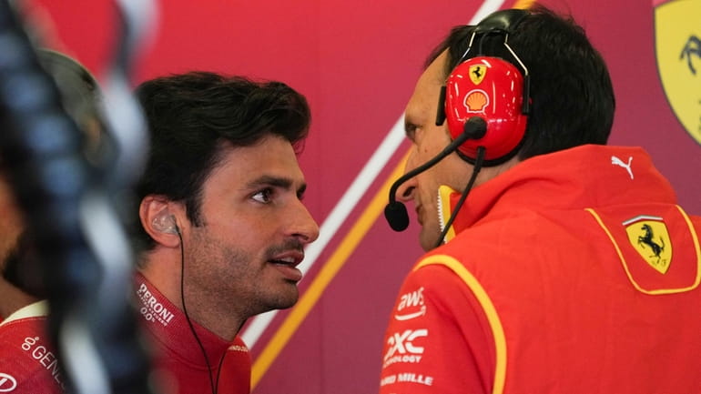 Ferrari driver Carlos Sainz, left, of Spain talks with a...