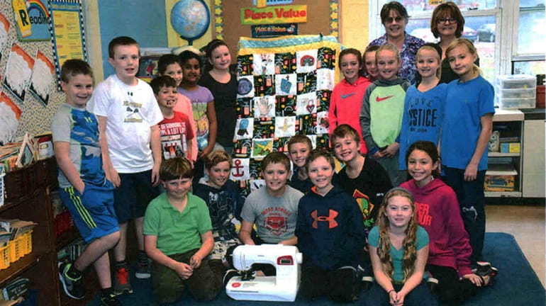 Kimberly Rall's fourth-grade class with their quilt and donated sewing...