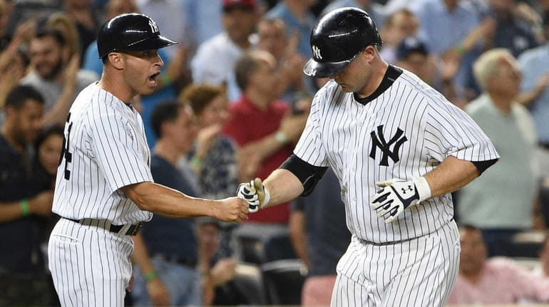 New York Yankees third base coach Joe Espada congratulates catcher...