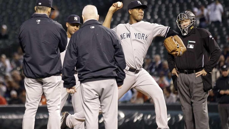 Yankees starting pitcher Ivan Nova, second from right, throws a...