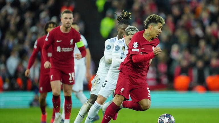 Liverpool's Roberto Firmino, right, is challenged by Real Madrid's Federico...