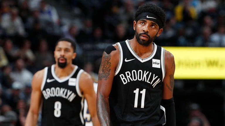 Nets guards Kyrie Irving, front, and Spencer Dinwiddie head to...