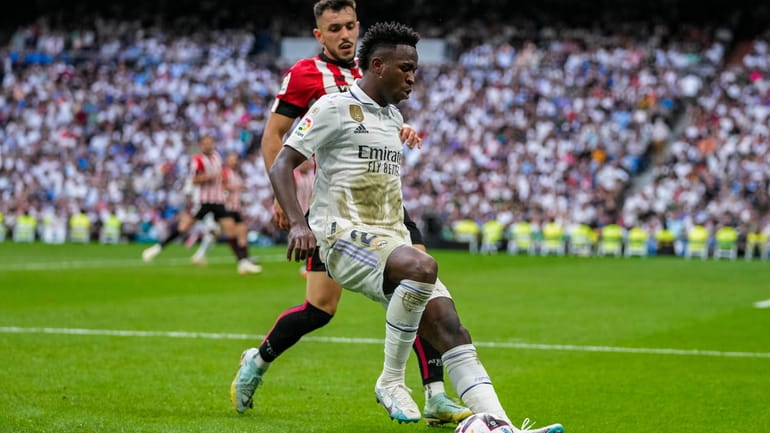 Real Madrid's Vinicius Junior, foreground, duels for the ball with...