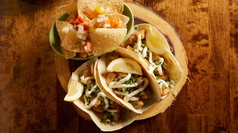 Fish tacos filled with coppery, crisp fried tilapia and a...