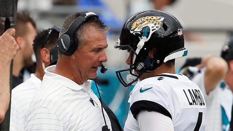 Jacksonville Jaguars head coach Urban Meyer, left, talks with place...