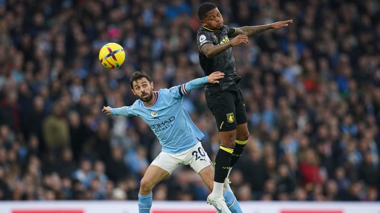 Manchester City's Bernardo Silva, left, challenges for the ball with...
