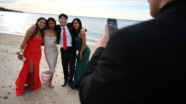 Seniors pose for pictures on the beach during cocktail hour...