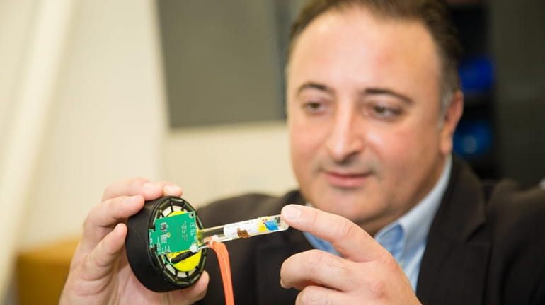 Marc Alessi, CEO of SynchroPET, shown holding the components of his...