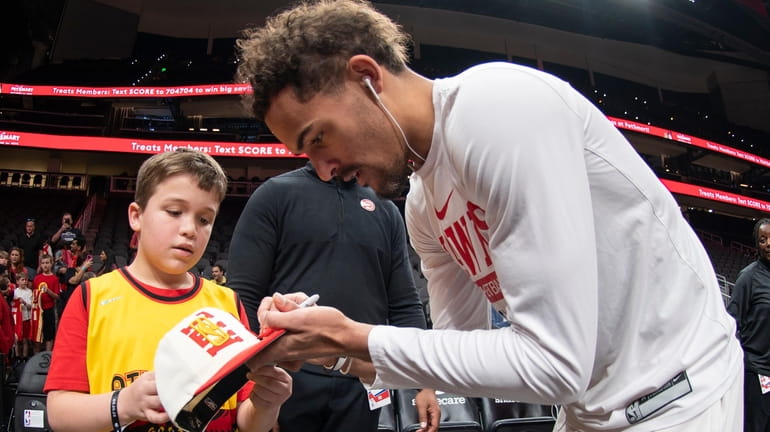 Atlanta Hawks guard Trae Young signs an autograph for a...