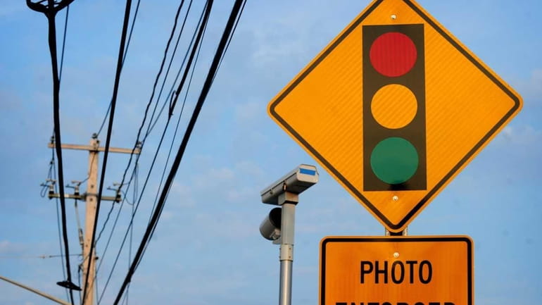 Motorists are warned by this sign about red-light cameras in...