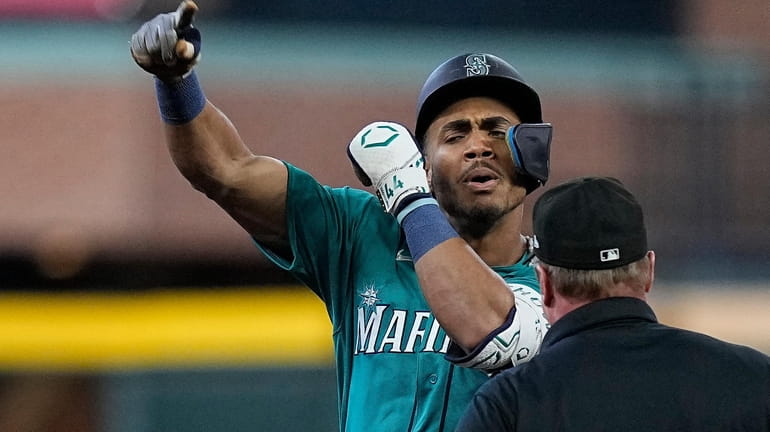 Seattle Mariners' Julio Rodriguez celebrates after hitting a leadoff double...