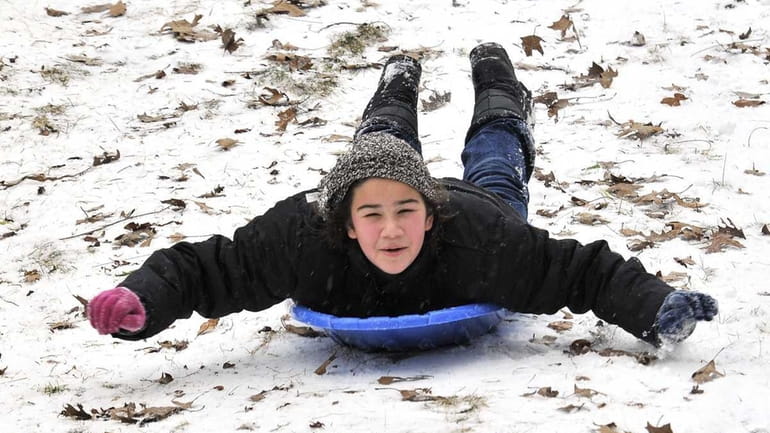 Eleven-year-old Katie Elefteriadis of South Farmingdale sleds down an embankment...