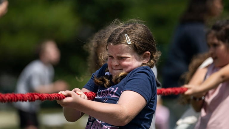 Third grader Fallon Reilly, 8, competes in the tug-of-war competition during...