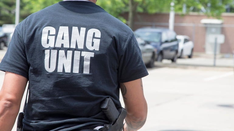 A member of the gang unit leaves Nassau police headquarters...