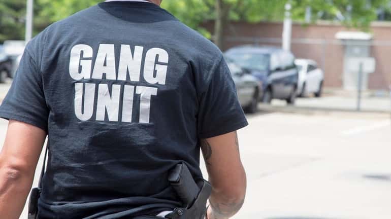 A member of the gang unit leaves Nassau police headquarters...