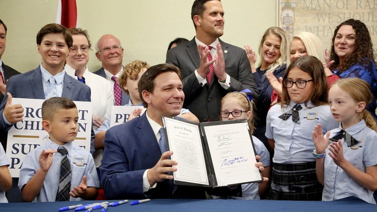 Florida Gov. Ron DeSantis displays the signed Parental Rights in...