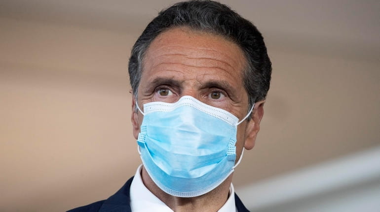 New York Gov. Andrew Cuomo wears a mask during a...