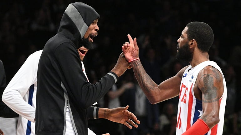 Nets guard Kyrie Irving reacts with forward Kevin Durant after...