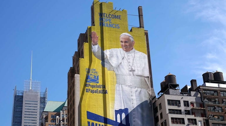 A huge portrait of Pope Francis is seen painted on...