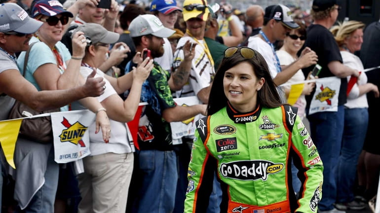 Danica Patrick smiles as she walks past fans during driver...