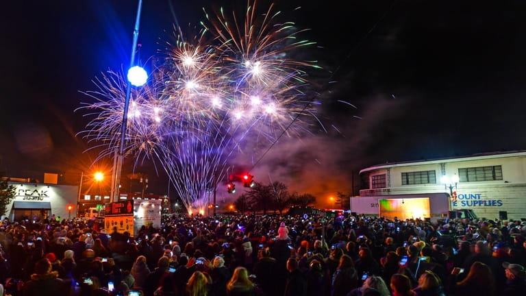 People celebrate New Years Eve by watching fireworks explode over...