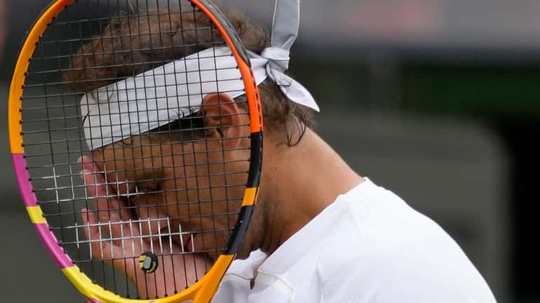 Rafael Nadal reacts after losing a point as he plays...