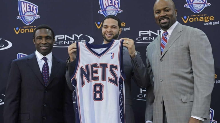 New Jersey Nets Deron Williams, center, holds up his jersey...