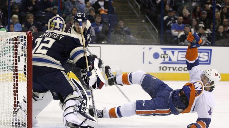 Islanders left wing Michael Grabner falls after being pushed by...