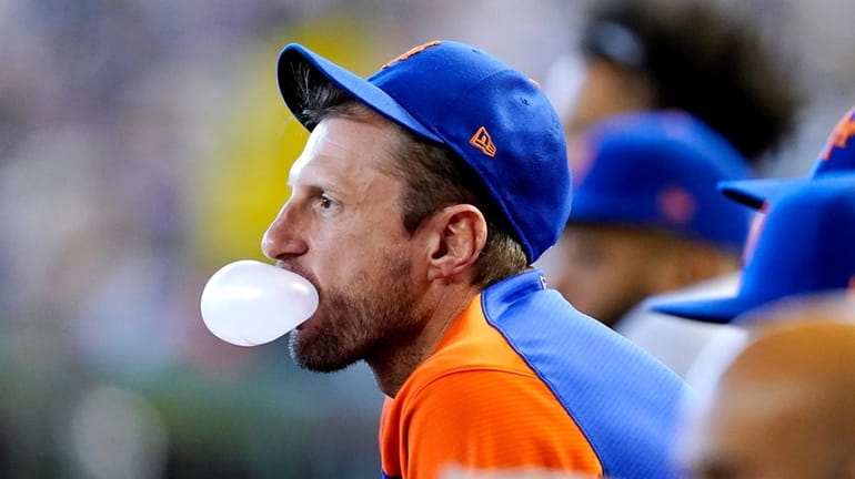 Mets starting pitcher Max Scherzer blows bubble from the dugout...
